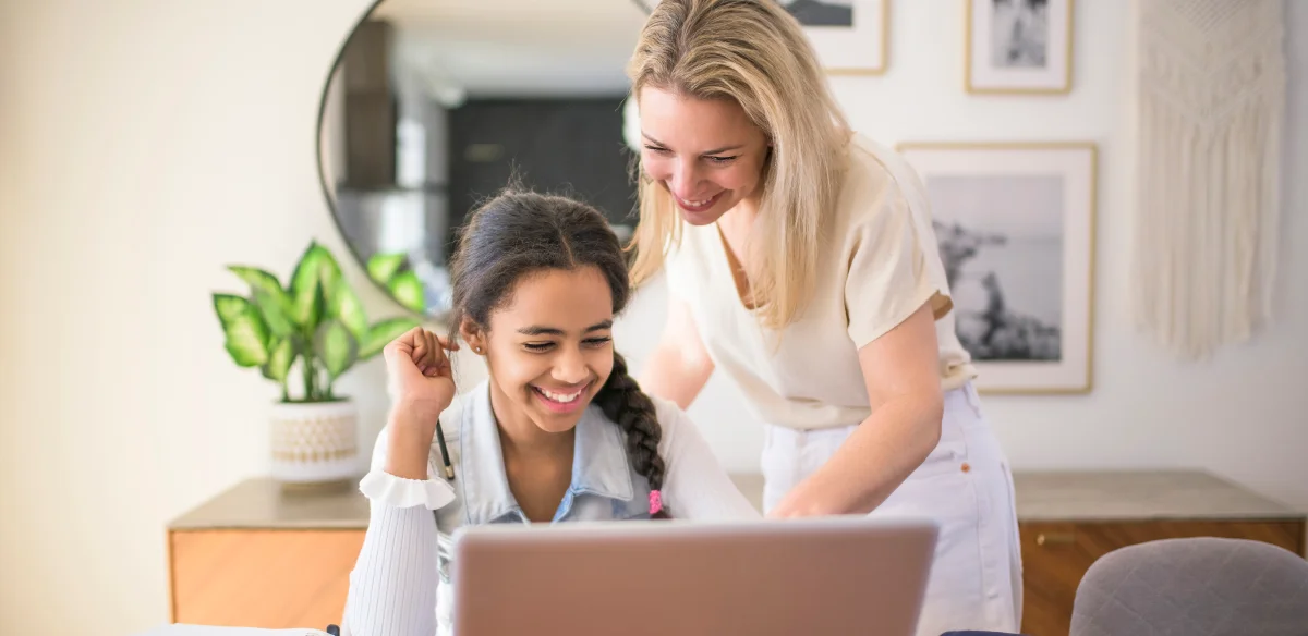 Mother and daughter working on their laptop together at home