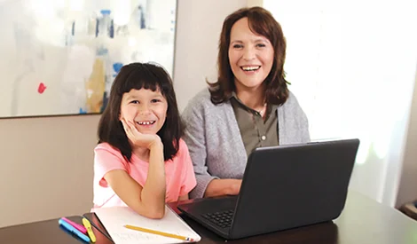 Mother and daughter working together with their laptop