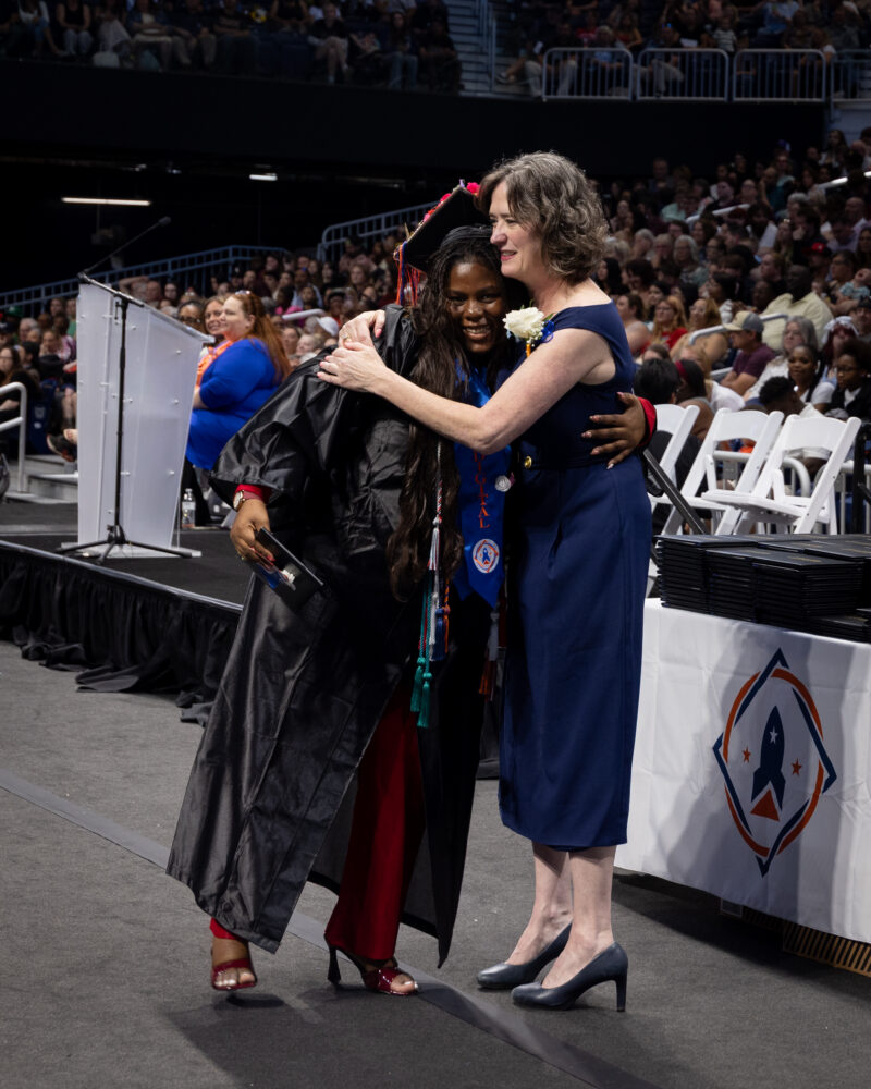 director hugging a student