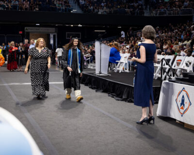 student walking for graduation diploma